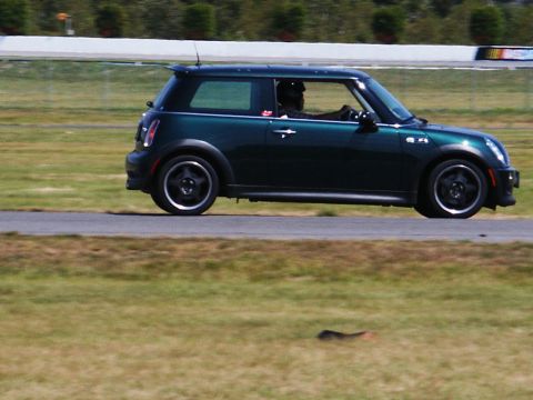 2001 Mercury Grand Marquis - A green Mini Cooper is seen on a race track with a driver wearing a helmet.