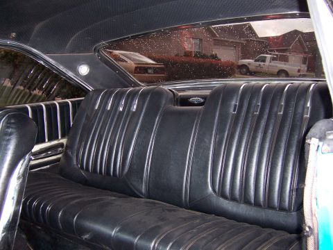 1963 Ford Galaxie - The interior of a classic car is shown, with a view of a suburban street scene through the rear window.