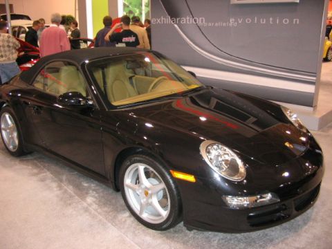 1994 Mazda 626 - Black convertible sports car with tan interior at an auto show.