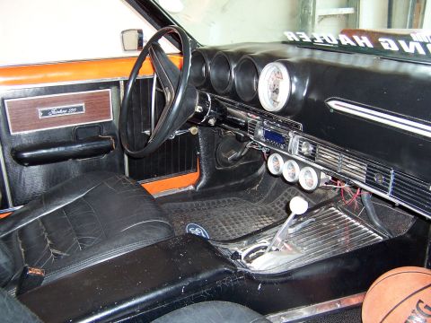1969 Ford Ranchero - Interior view of a 1969 Ford Ranchero, aftermarket gauges and a wood-grain door panel.