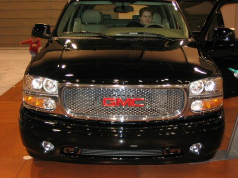 1994 Mazda 626 - Front view of a black GMC Yukon, a prominent chrome grille with a red GMC emblem.