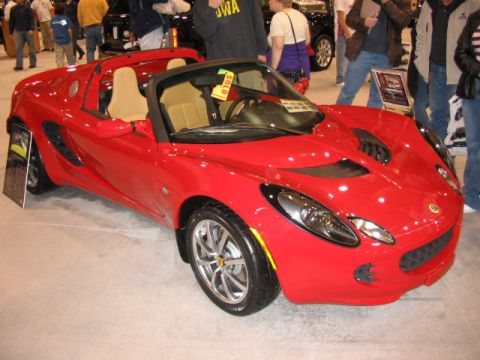 1994 Mazda 626 - Red convertible sports car with tan interior on display at an auto show.