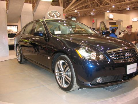 1994 Mazda 626 - An Infiniti M sedan is displayed at an auto show, with the brand's logo prominently featured.