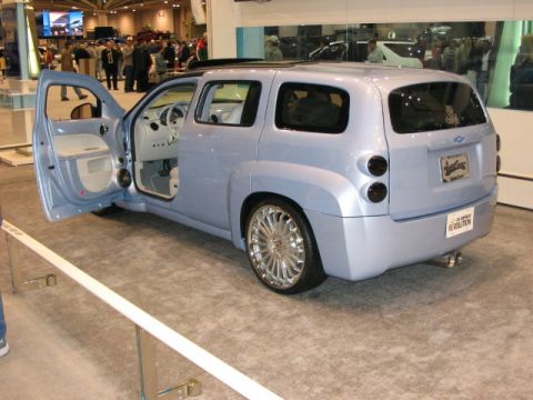 1994 Mazda 626 - Custom light blue hatchback on display at an auto show, unique styling and large chrome wheels.