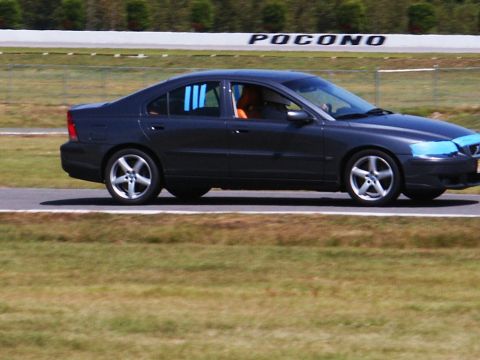 2001 Mercury Grand Marquis - A dark sedan is seen on a race track, with the word 'Pocono' visible on a sign in the background.