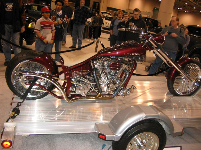 Red custom chopper motorcycle on a trailer, side view