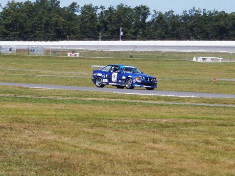 2001 Mercury Grand Marquis - A blue BMW M3 is seen on a race track during a sunny day.