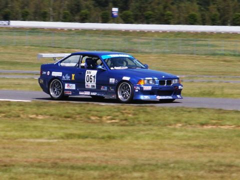 2001 Mercury Grand Marquis - A blue BMW M3 race car is seen on a track, displaying the number 061.