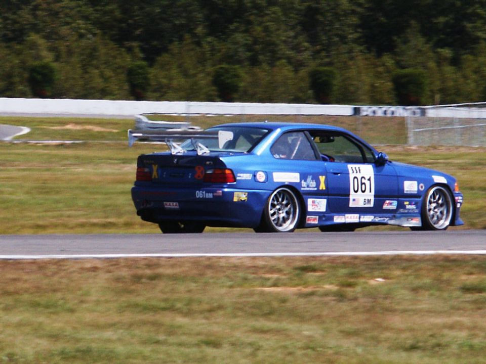 Blue race car with large rear spoiler and number 061 on door