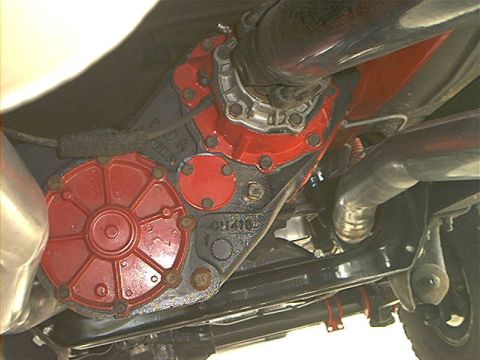 1978 Ford Bronco - Underbody view of a front axle housing with a red-painted differential cover and pinion snout, the driveshaft and U-joint bolted to the yok…