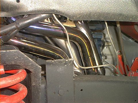 1978 Ford Bronco - View up into the engine bay from below showing polished stainless headers with heat-tinted primary tubes snaking down past the frame rail.…