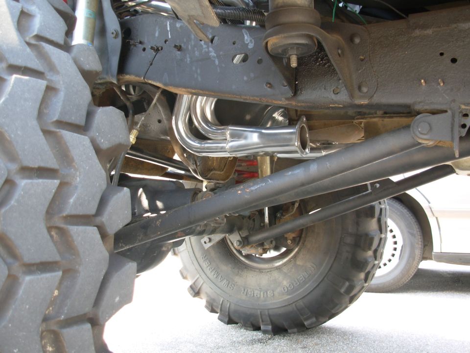 Stainless headers and red springs under a lifted 4x4 on Super Swamper tires