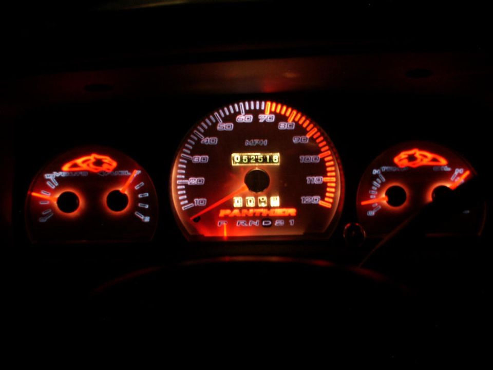 Illuminated red gauge cluster with speedometer, odometer 052516 and PANTHER text