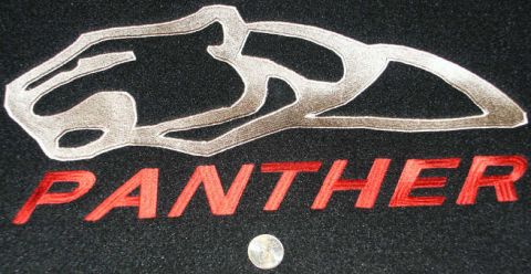 2001 Mercury Grand Marquis - Close-up of an embroidered panther logo and the word "PANTHER" on a black background, with a coin for scale.