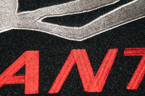 2001 Mercury Grand Marquis - Embroidered text on a black fabric surface, possibly from a car mat or apparel.