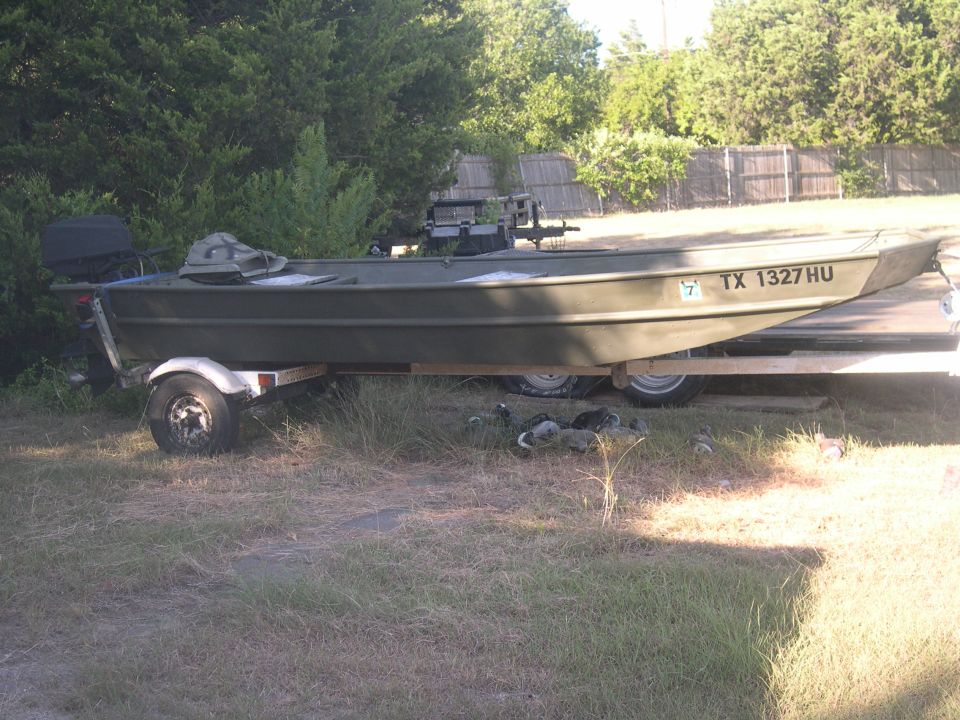 Olive green jon boat with TX 1327 HU registration on a trailer
