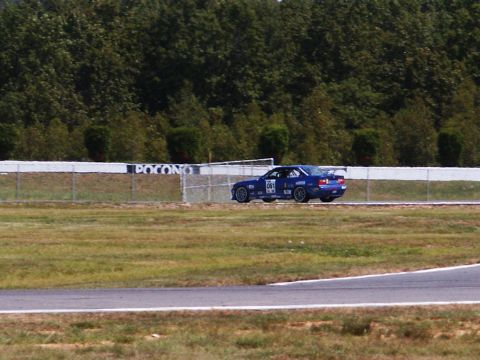 2001 Mercury Grand Marquis - A blue race car speeds around a track, with the Pocono Raceway sign visible on the wall.