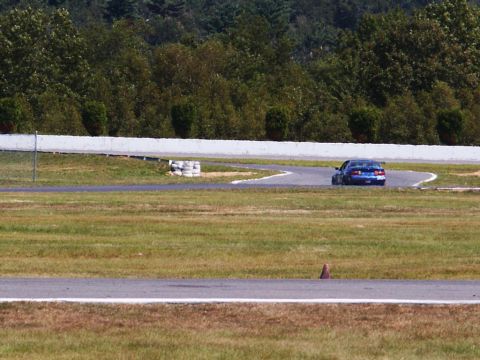 2001 Mercury Grand Marquis - A blue sedan navigates a turn on a race track during a sunny day.