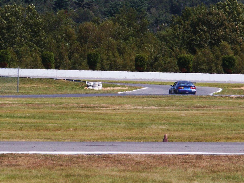 Blue sedan on a race track corner