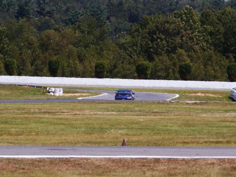 2001 Mercury Grand Marquis - A blue sedan navigates a turn on a race track.
