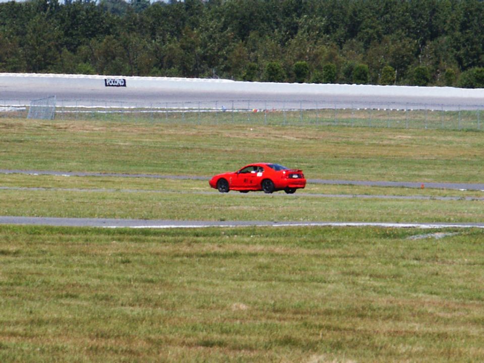 Red sports car on a race track, rear view