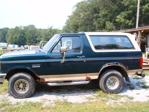 1993 Ford Bronco - Side profile of a 1993 Ford Bronco, noted for its two-tone paint and visible rust damage.