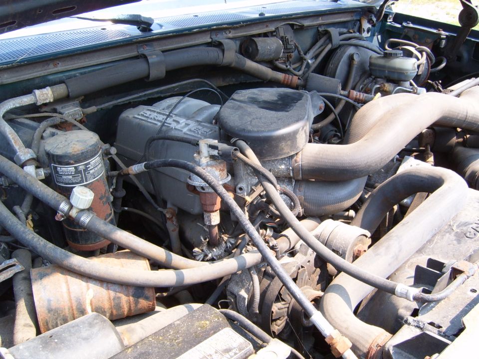 engine bay with hoses, filters, and engine components visible