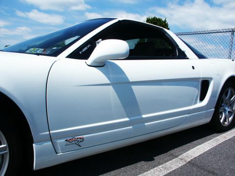 2001 Mercury Grand Marquis - A white sports car is parked outdoors, with a fence in the background and a blue sky above.