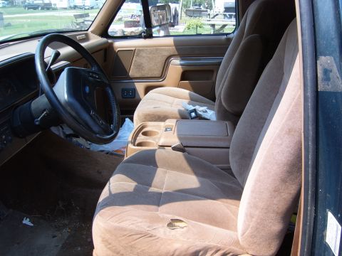 1993 Ford Bronco - Interior view of a vehicle's tan seats, steering wheel, and center console.