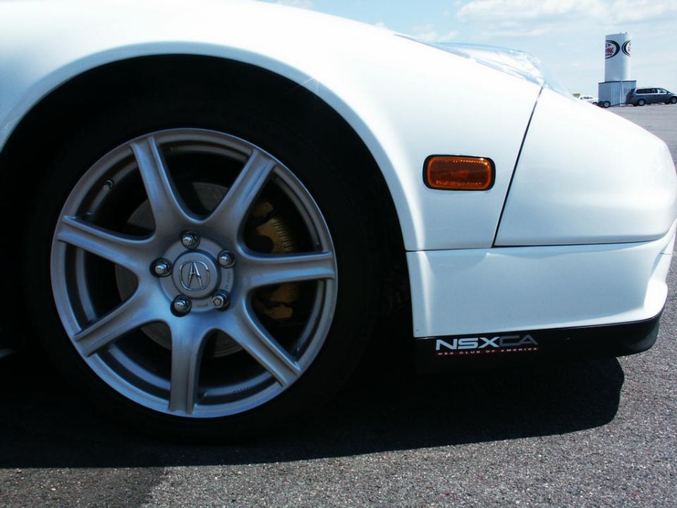 White Acura NSX front corner with alloy wheel and NSXCA badge on the side skirt
