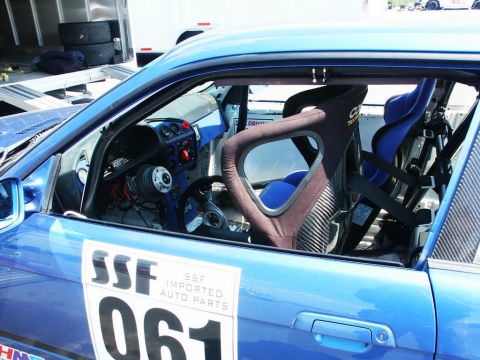2001 Mercury Grand Marquis - Interior of a blue race car with racing seats and roll cage. 'SSF IMPORTED AUTO PARTS' and number 061 are on the door.