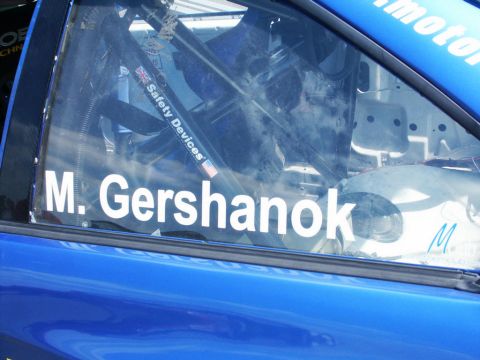 2001 Mercury Grand Marquis - A close-up view of the interior of a blue race car, showing the roll cage and driver's name on the window.