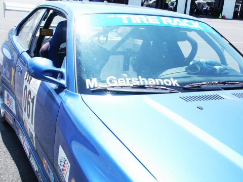 2001 Mercury Grand Marquis - Close-up of a blue race car's interior and side, showing racing modifications and sponsor decals.