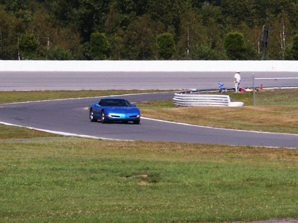 Blue convertible sports car on a race track, driver visible