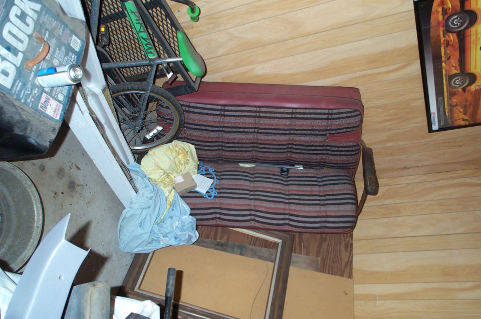 Striped vehicle seats and a bicycle wheel inside a garage