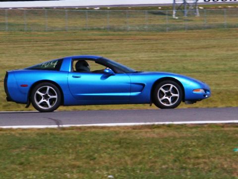 2001 Mercury Grand Marquis - A blue Corvette is seen on a race track, with a driver wearing a helmet.