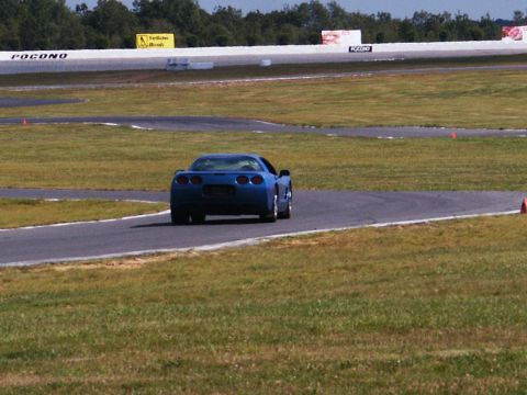 2001 Mercury Grand Marquis - Blue Chevrolet Corvette C5 navigates a turn on a race track.