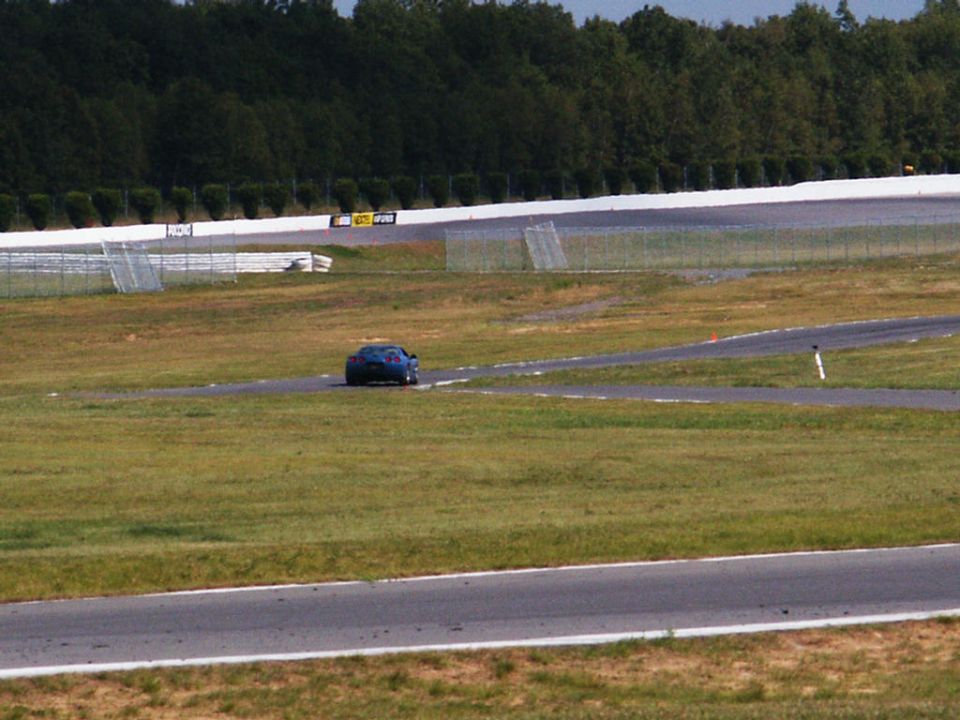Blue sports car on a race track, rear view