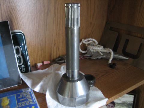 1986 Ford F-150 - A metal driveshaft component, likely for a truck or SUV, is displayed on a shelf.