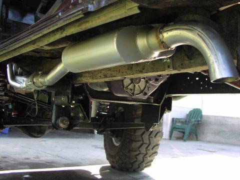 1979 Ford Bronco - Close-up of the vehicle's undercarriage shows the custom exhaust system and transmission components.