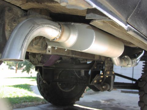 1979 Ford Bronco - Close-up view of a vehicle's custom exhaust system and rear axle components.