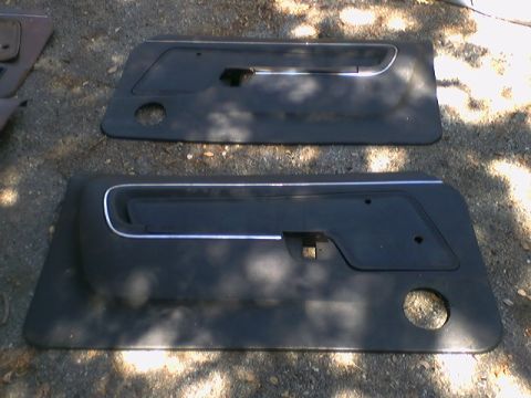 1973 Ford Ranchero - Two car door panels are shown, likely for a classic vehicle, resting on a gravel surface.