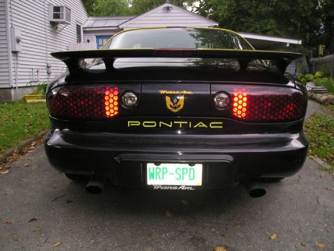 1984 Pontiac Fiero - The rear of a black 1994 Pontiac Trans Am is shown parked in a driveway.