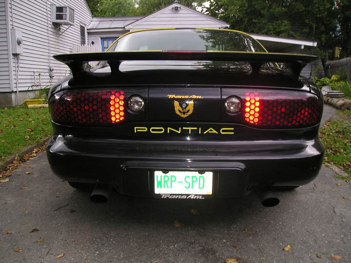 Rear of a black 1994 Pontiac Trans Am with a spoiler and honeycomb taillights