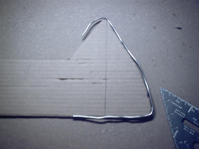So then we take the silver solder and lay it on a piece of cardboard and trace it. Here we have the entire passenger side forward panel already cut, with the silver solder showing that our contour matches.