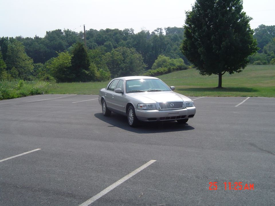 2006 Mercury Grand Marquis parked in an empty lot with trees in the background