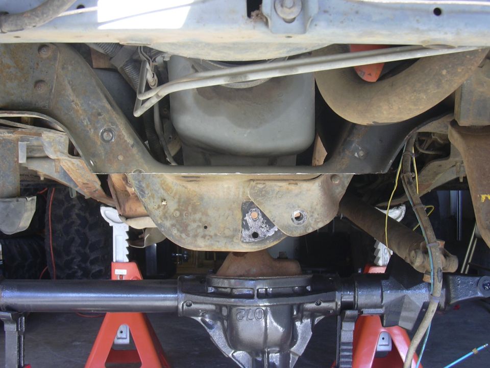Undercarriage view showing a differential and suspension components, vehicle supported by jack stands