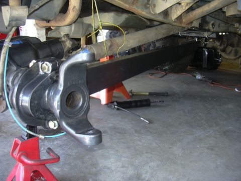 1991 Ford Bronco - Underbody view of a vehicle's suspension system, showing the axle, leaf spring, and shock absorber.