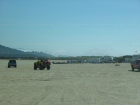 1995 Ford Bronco - Off-road vehicles and RVs are gathered on a sandy beach under a clear blue sky.