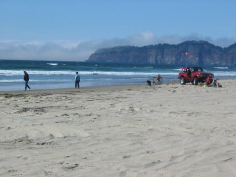 1995 Ford Bronco - Red 1995 Ford Bronco on the beach with people enjoying the day by the ocean.